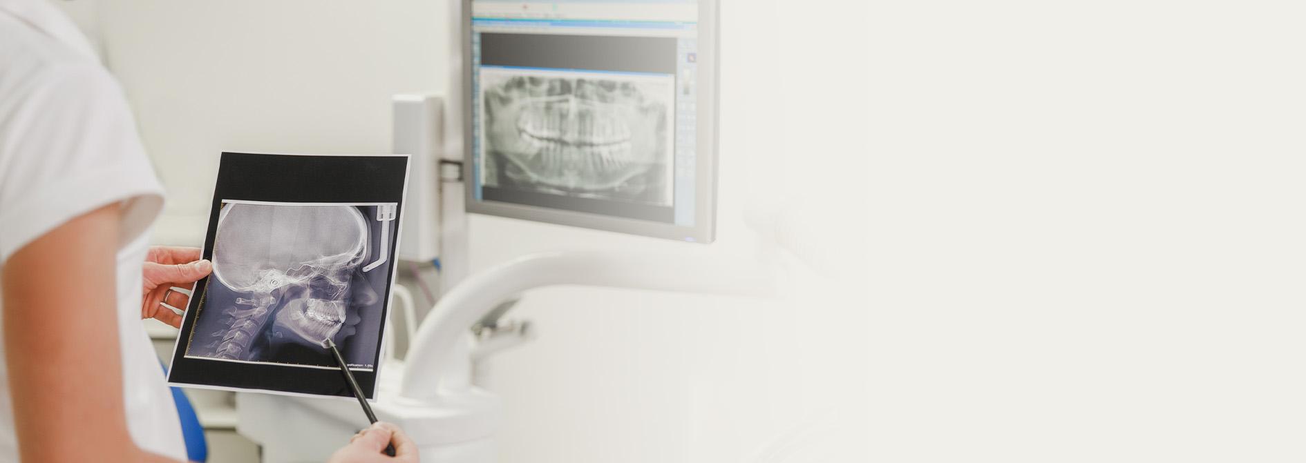 Slajd #5 - dentystka trzymająca prześwietlenie